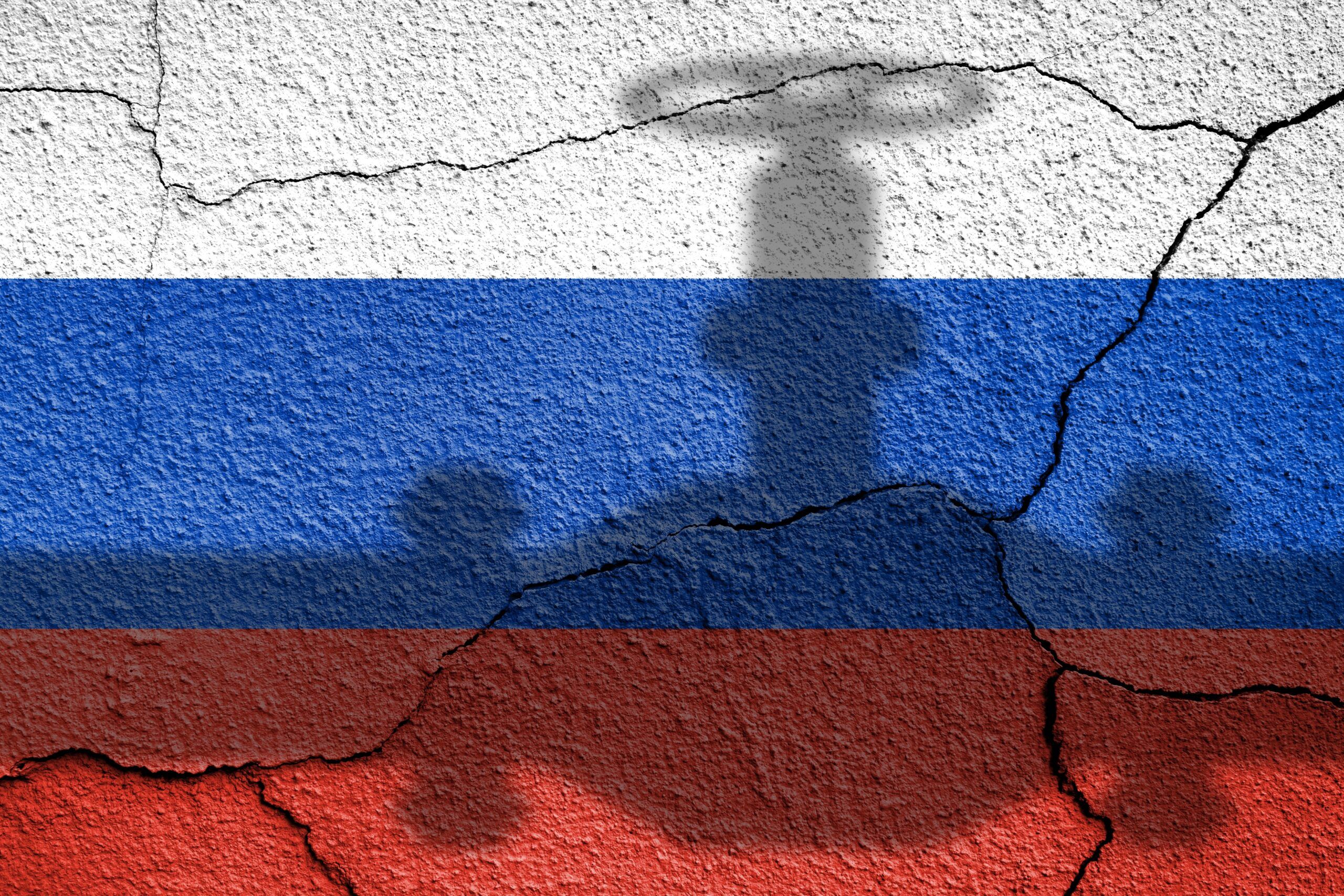 Flag of Russia painted on a concrete wall with gas, oil pipe shadow